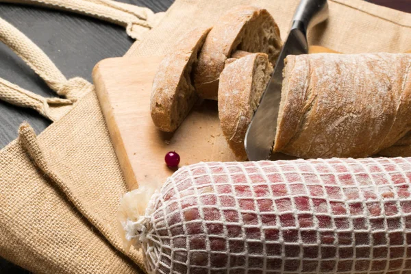 Pane ciabatta con salame in tavola di legno — Foto Stock