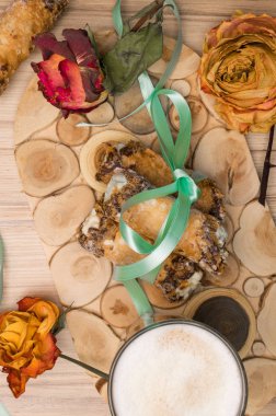 Cannoli tatlılar ahşap tahta üzerinde gül dekorasyonu ile