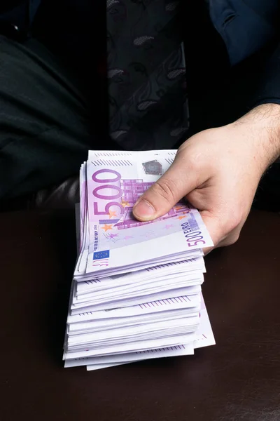 Homme en costumes hommes.Corruption et corruption avec des billets en euros. Homme tenant beaucoup d'argent — Photo
