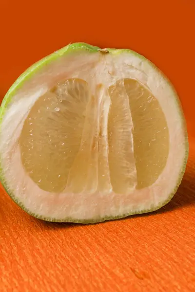 Verse groene grapefruit op de oranje achtergrond — Stockfoto