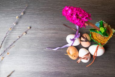 Paskalya yumurtaları renkli kurdeleler ve pembe geocint çiçek uğur böceği ile süslenmiş