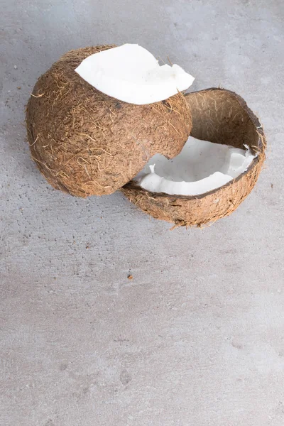 Raw organic broken coconut on grey table — Stock Photo, Image