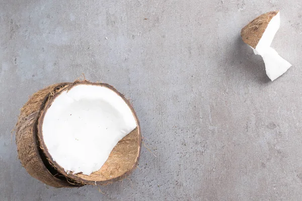 Coco quebrado orgânico cru na tabela cinzenta — Fotografia de Stock