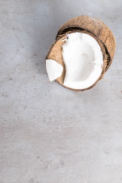 Noix de coco cassée bio crue sur table grise — Photo