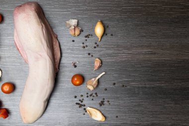 Ham, sebze ile sığır eti veya domuz eti dil üzerinde bir arka plan siyah yakın çekim bir kesme tahtası üzerinde yatıyor