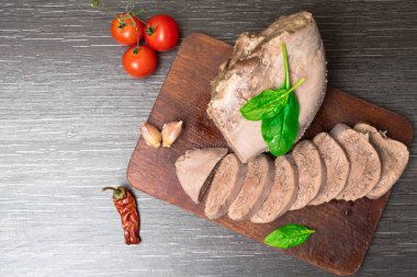 Ahşap arka plan üzerine haşlanmış sığır eti, domuz eti dil domates, fesleğen yaprağı, atış, stüdyo ile izole.