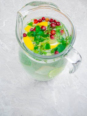 Taze limon ve limon dilimli ev yapımı limonata, nane yaprağı, masada kırmızı böğürtlen.