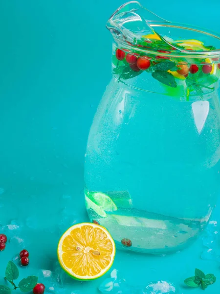 Фруктові та ягідні лимонадні напої, освіжаючі напої наливають воду, у скляні банки, зі свіжою журавлиною, скибочками лимона та лайма на синьому фоні — стокове фото