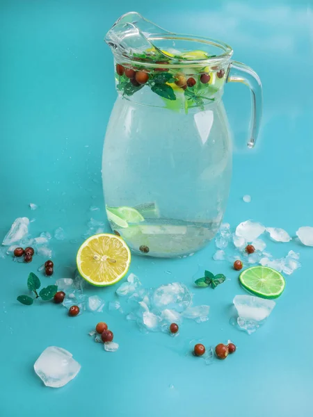 Bebidas de limonada de frutas e bagas, água de refresco infundida, em frascos de vidro, com cranberries frescas, limão e fatias de limão no fundo azul — Fotografia de Stock