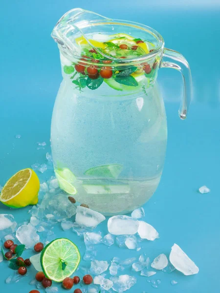 Bebidas de limonada de frutas e bagas, água de refresco infundida, em frascos de vidro, com cranberries frescas, limão e fatias de limão no fundo azul — Fotografia de Stock