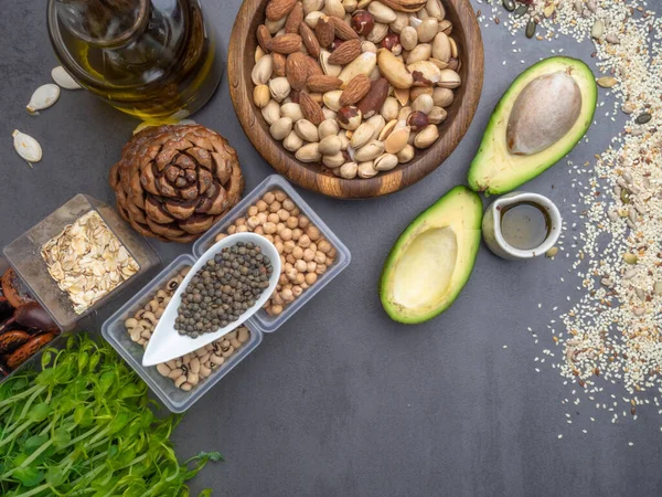 Healthy fat sources and healthy food that is useful for heart - avocado, seeds, microgreens, nuts, beans, oatmeal ang oils. Diet and healthy lifestyle concept. Vegetarian