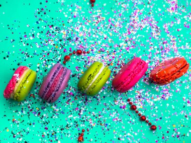 Renkli konfeti ve naneli turkuaz arka planda badem kurabiyesi ile şenlikli bir daire. Tatil konsepti, seçici odaklanma