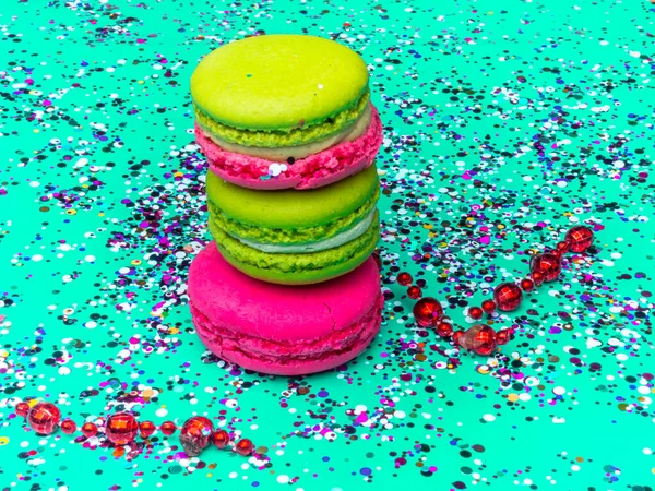 Macaroons coloridos com polvilhas coloridas na cor tendência fundo de hortelã verde. close-up. Comida festiva doce e saborosa — Fotografia de Stock