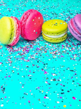 Turkuaz arka planda pasta ya da kurabiye konfeti, renkli badem kurabiyeleri, şenlikli kart, seçici odak