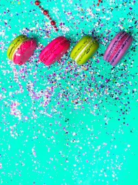 Renkli konfeti ve naneli turkuaz arka planda badem kurabiyesi ile şenlikli bir daire. Tatil kavramı.