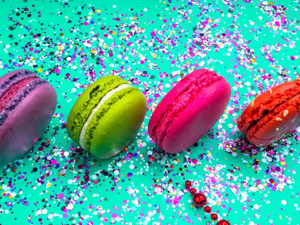 Renkli konfeti ve naneli turkuaz arka planda badem kurabiyesi ile şenlikli bir daire. Tatil kavramı.