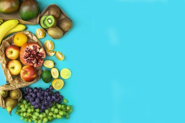 Meyve ve sebzeler antioksidan, vitamin ve lif açısından zengin mavi arka planda. Sıfır atık yiyecek alışverişi, eko doğal kağıt torbaları düz konum tarzı