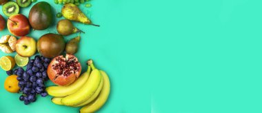 Antioksidan açısından zengin meyveler, naneli yeşil arka planda vitamin ve lif. Düz yatıyordu. Çiğ, vejetaryen, vejetaryen, alkali gıda konsepti.