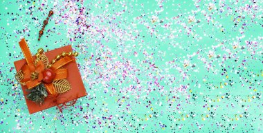 Turkuaz arka planda kırmızı süslemeli, renkli simli kırmızı hediye kutusu. Tatil konsepti. Üst görünüm