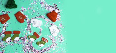 Renkli ışıltılı holografik parıltı konfetileri, oyuncak şapkalar, eldivenler, botlar. Noel tatilleri soyut arka plan, 2020 yılının neo nane rengiyle izole edilmiş.