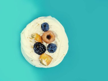 Kremalı Pavlova taze olgun ahududu, çilek, yabanmersini, naneli krem şanti, şenlikli konfeti