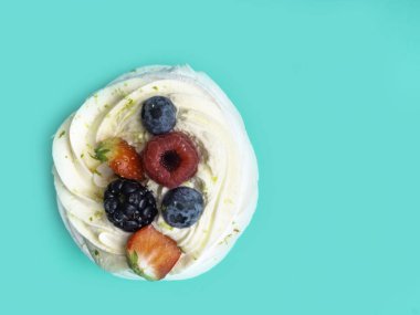 Kremalı Pavlova taze olgun ahududu, çilek, yabanmersini, naneli krem şanti, şenlikli konfeti