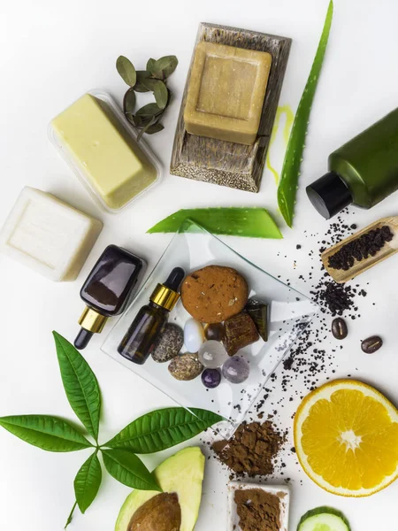 beauty and organic spa products, skincare natural ingredients,, acessories, serum, soap, scrub, oil, cocoa butter, stone for massage, orange, avocado slices, home-spa concept. Light background, top vi
