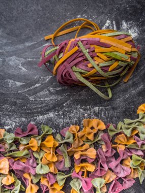 Çiğ makarna çeşitleri, farfalle papyonlu, fettucine ya da tagliatelle rengarenk unlu makarna.