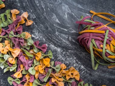 Çiğ makarna çeşitleri, farfalle papyonlu, fettucine ya da tagliatelle rengarenk unlu makarna.