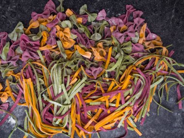 Çiğ makarna çeşitleri, farfalle papyonlu, fettucine ya da tagliatelle rengarenk unlu makarna.