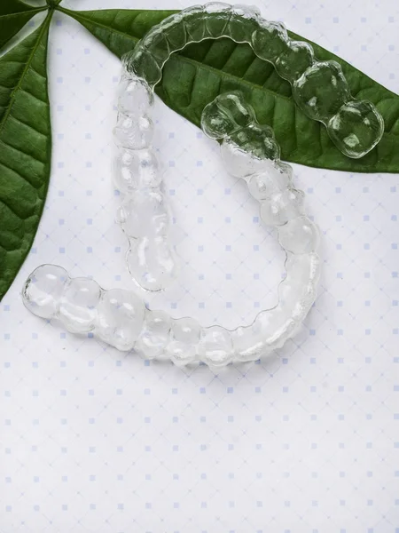 Dişleri yeşil yapraklarla düzleştirmek için ortodontik hizalayıcı, yeşil iyi plastik kavramı