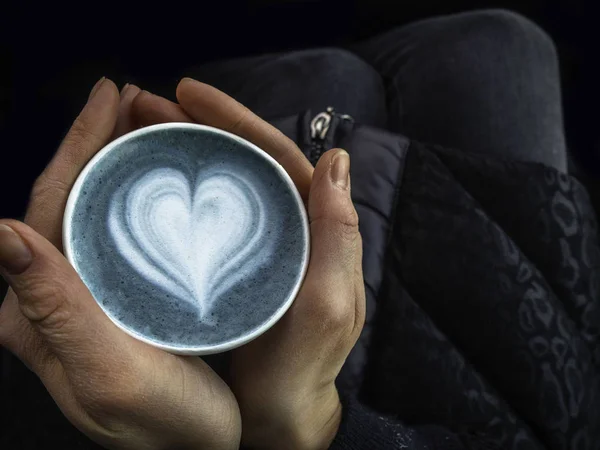 Arte latte matcha azul en taza de papel ecológico. Color principal 2020 concepto de año. Una taza de café manos femeninas en el coche. Composición mínima . — Foto de Stock