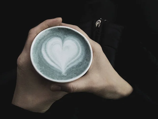 Tasse ecofriendly de latte matcha bleu frais et tendance dans les mains de la femme. Du latte art classique. Place vide pour le texte, espace de copie. Dépendance au café. Vue du dessus — Photo
