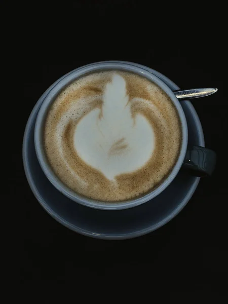Latte beau café des arts. Tasse bleue de café chaud sur la surface noire . — Photo