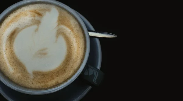 Café de arte con leche. Taza azul de café caliente en la superficie negra . — Foto de Stock