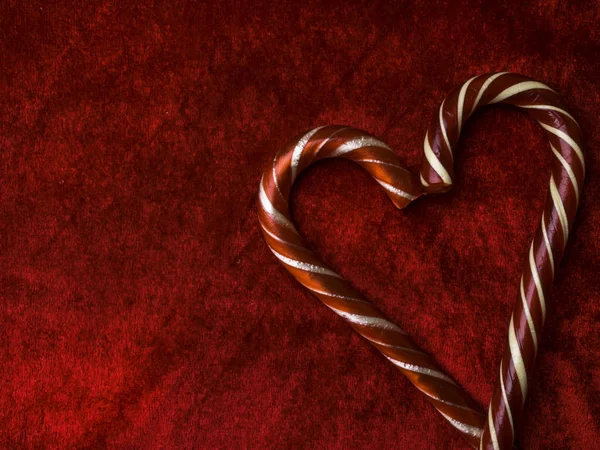 candy canes making a heart on a red velvet background, Valentine day, Christmas, love concept, copy space