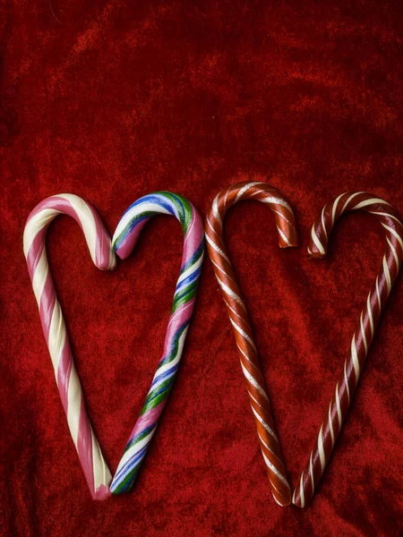 Candy canes making a heart on a red velvet background, Valentine day, Christmas, love concept, copy space — Stock Photo, Image