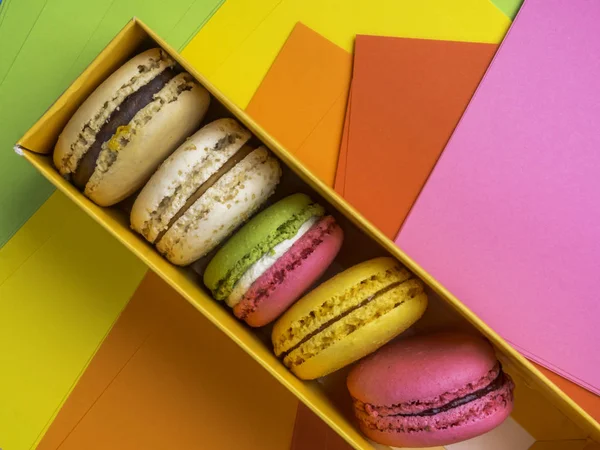 Colorful macaroons in box on festive colorful background — Stock Photo, Image