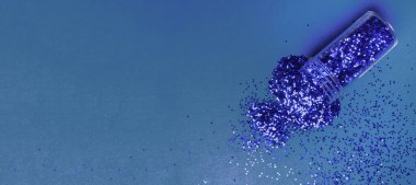 Mavi modaya uygun arka planda mavi renkli simli bir şişe. Moda mavi renk konsepti. Tırnak sanatı için parıltı