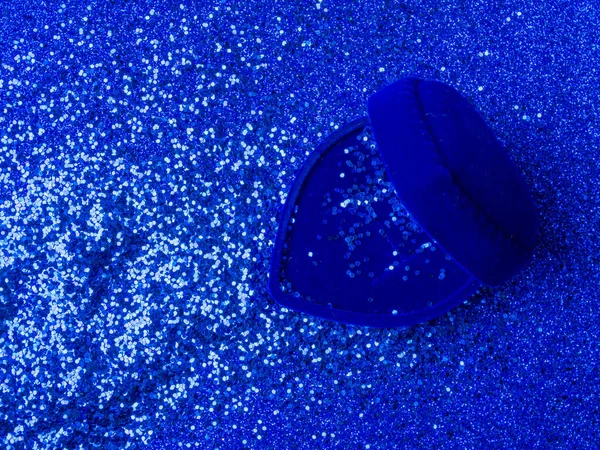 Голубая бархатистая кольцевая коробка в форме сердца с глиттерами на трехмерном синем фоне. Подарок на день Святого Валентина или день рождения. Копирование текста — стоковое фото