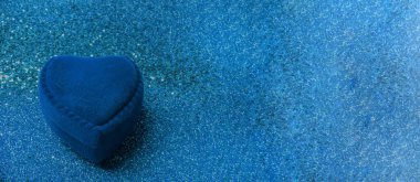 Mavi kadife kalp şeklinde halka kutusu ve parlak mavi arka plan. Sevgililer günü ya da doğum günü hediyesi. Metin için alanı kopyala