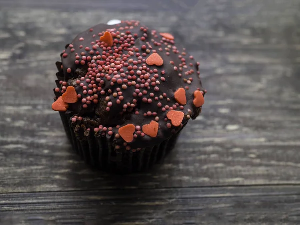 Schokoladen-Cupcake mit Dekorationen für Valentinstag, Muttertag, Geburtstagstorte. ein festliches Dessert, Liebestorten mit dekorativen süßen Herzen, herzförmige Streusel — Stockfoto