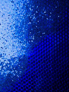 2020 color trend. Festive background of blue color glitter on trendy blue surface.