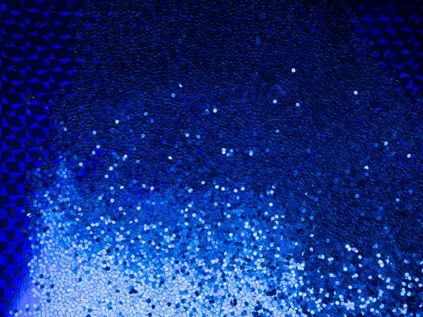 Tendenza colore 2020. Sfondo festivo di brillantini di colore blu sulla superficie blu alla moda . — Foto Stock