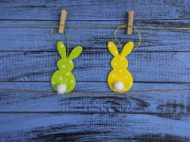 Paskalya bayramı konsepti, yeşil ve sarı tavşan oyuncağı moda mavi ahşap arka planda