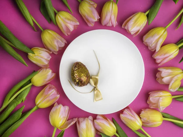 Bord met gouden paaseieren, strik, tulpen — Stockfoto