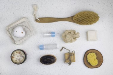 Banyo aksesuarları, sabunlar, vücut fırçası, gül yapraklarıyla ovalama, kozmetik için şişeler, beyaz arka planda sünger, üst manzara, kapat. Spa konsepti