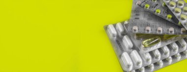 Sarı arka planda su toplayan kapsüller ve haplar. Haplar. Tıp sembolü. İlaç ilaçları. Boşluğu kopyala