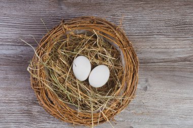 Paskalya sepeti ya da eski ahşap arka planda paskalya yumurtaları olan kuş yuvası