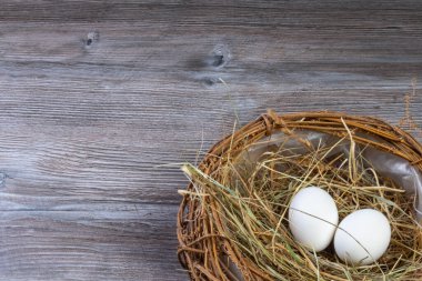 Paskalya sepeti ya da eski ahşap arka planda paskalya yumurtaları olan kuş yuvası